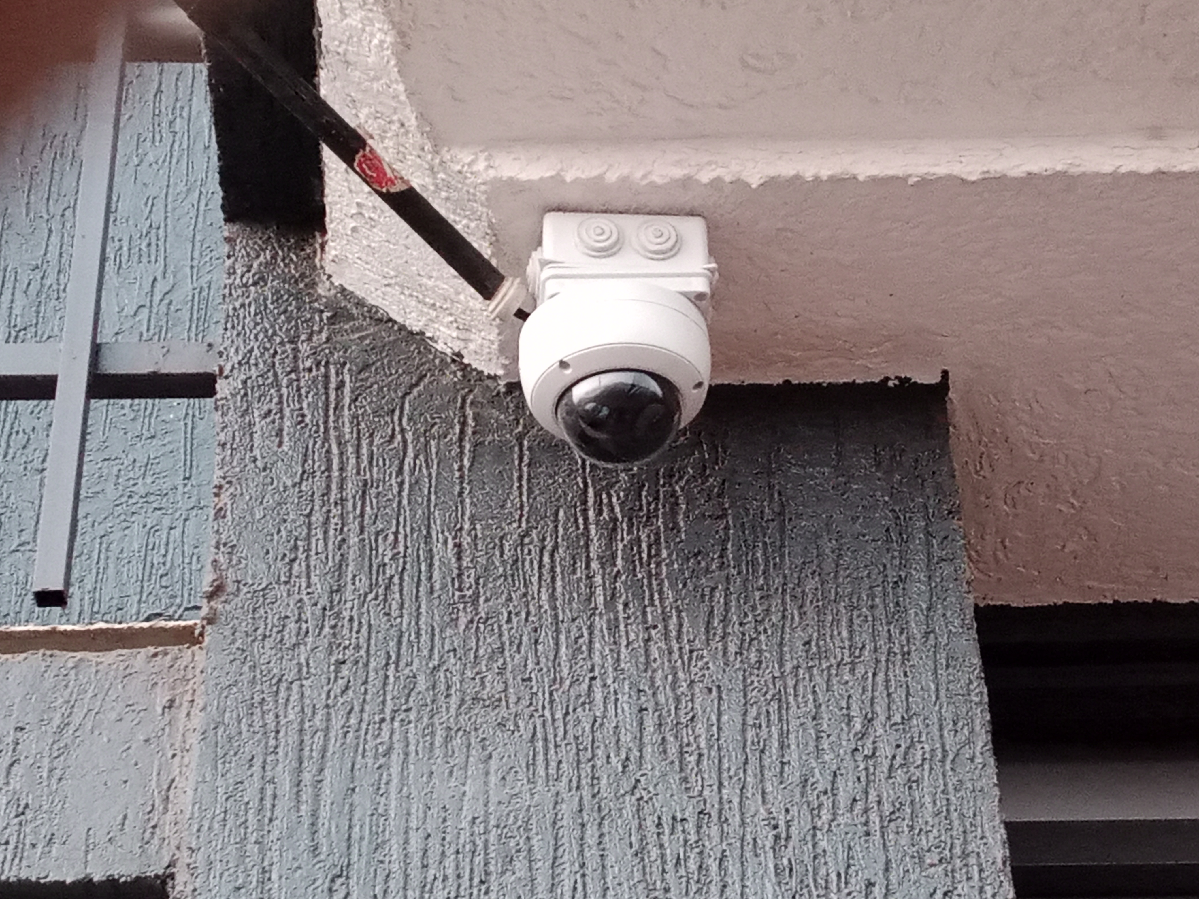 A front view of a dome CCTV camera mounted outdoor on adapter box
