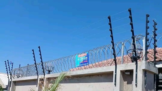 A combination of razor and electric fence installed on a wall fence