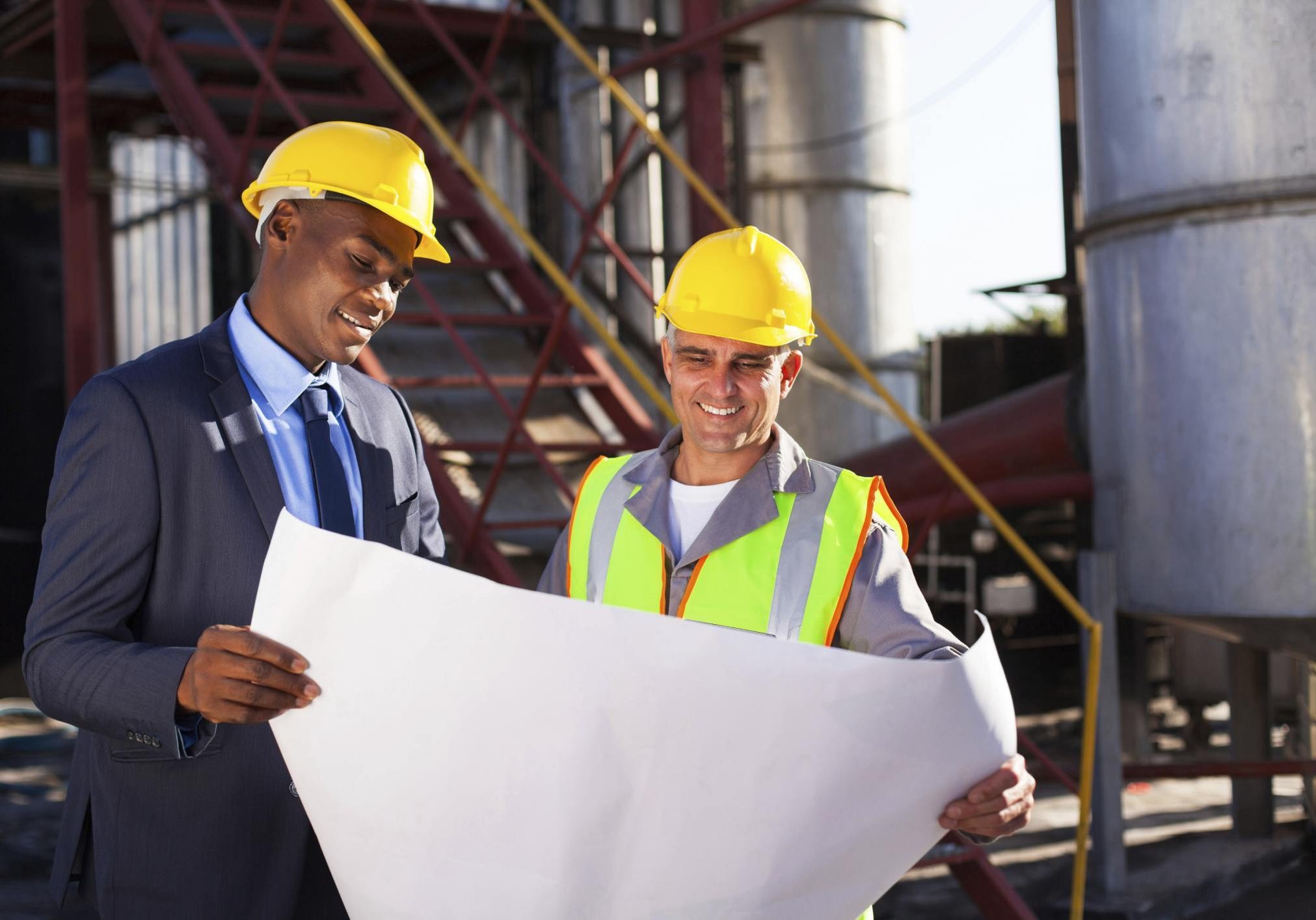 Two engineers looking at a drawing of a building
